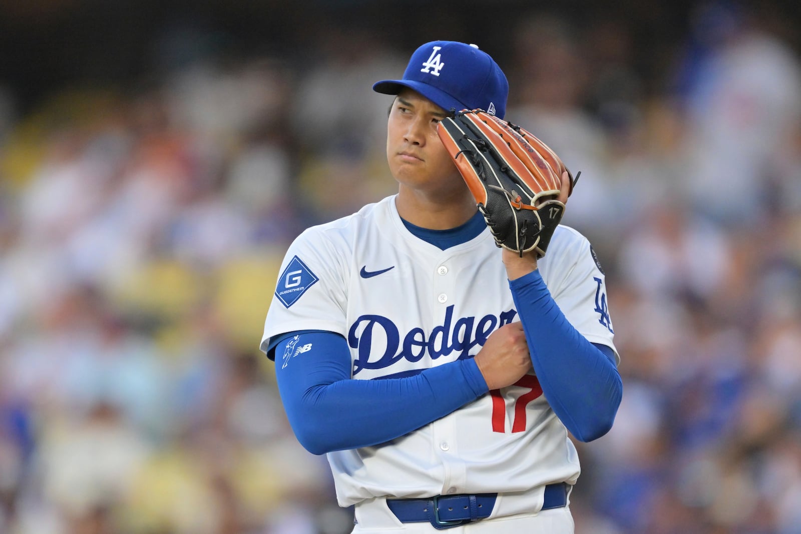 Los Angeles Dodgers pitcher Shohei Ohtani listens to the PitchCom during the first inning of a baseball game against the Minnesota Twins in Los Angeles, Monday, July 21, 2025. (AP Photo/Jayne Kamin-Oncea)