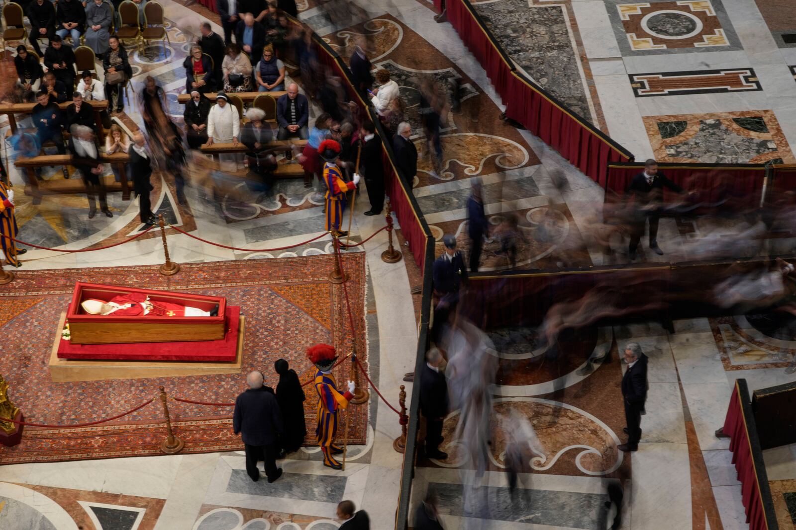 People pay their respect to the late Pope Francis who will lie in state inside St. Peter's Basilica until Friday, at the Vatican, Thursday April 24, 2025. (AP Photo/Gregorio Borgia)
