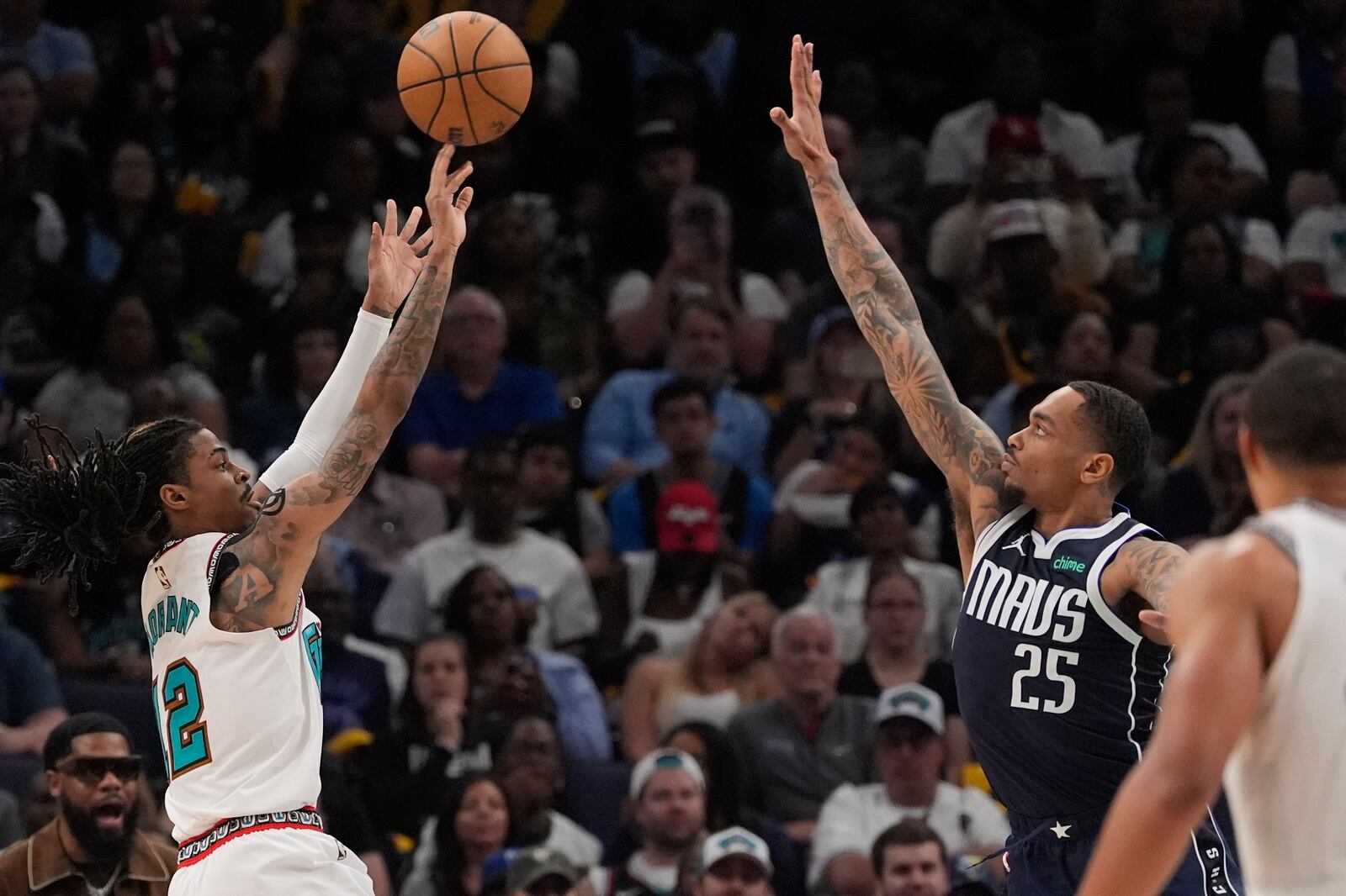 Memphis Grizzlies guard Ja Morant, left, shoots the ball over Dallas Mavericks forward P.J. Washington (25) during the second half of an NBA play-in tournament basketball game Friday, April 18, 2025, in Memphis, Tenn. (AP Photo/George Walker IV)