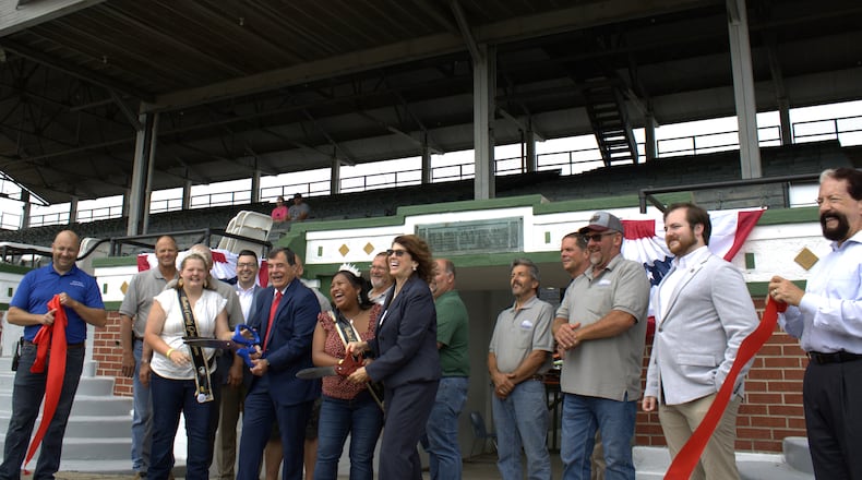Local officials, leaders and representatives gathered around the grandstands at the Butler County Fairgrounds on July 22, 2024 for a ribbon-cutting ceremony that unveiled the updates from the $750,000 restoration that took place in the past year. The restoration focused on the structural integrity of the grandstands and cosmetic maintenance. KASEY TURMAN/STAFF