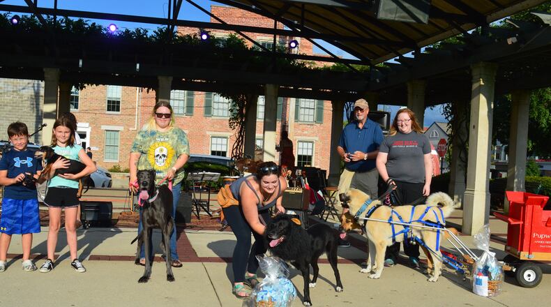 Prize winners of the Dog Days judging during the Red Brick Friday contest gathered for a photo. Shown above (from left) are Lou, winner of the shortest dog award at 10 inches; Marley, the tallest dog at 35 inches; Severus, best costume winner dressed as a lion; and Asil, one of two dogs pulling the Pupweiser wagon, winner of the longest tail, at 20 inches. In back is Mayor Bill Snavely who served as judge. CONTRIBUTED/BOB RATTERMAN
