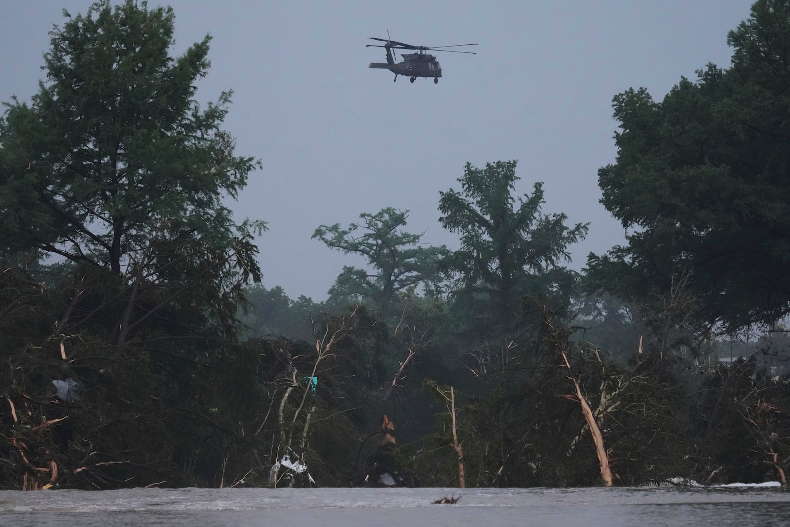 A helicopter flies over the Guadalupe River after a flash flood swept through the area, Friday, July 4, 2025, in Kerrville, Texas. (AP Photo/Eric Gay)