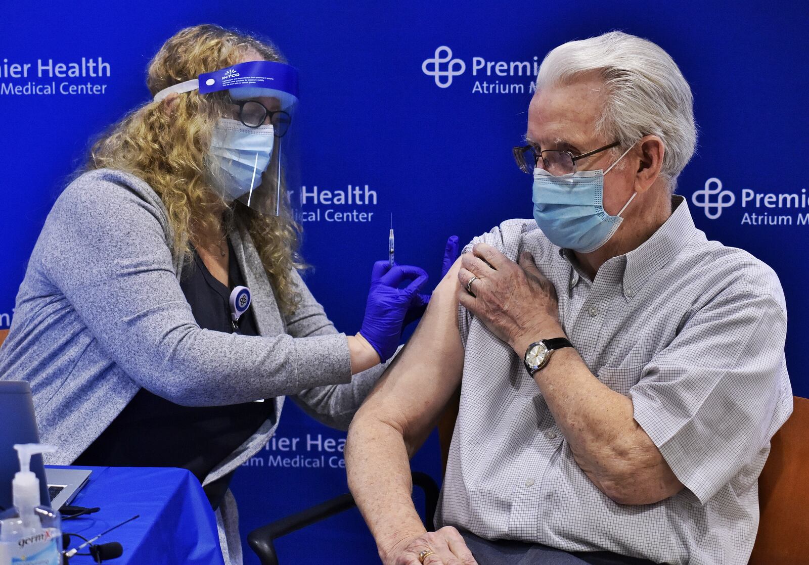 Atrium Medical Center LPN Tami Arnold administered one of their first phase 1B covid vaccines to Don Pelfrey Tuesday, January 19, 2021 in Middletown. Premier Health has 1100 vaccines network wide and 100 for Atrium Medical Center for this community vaccine clinic. Pfizer vaccines were given to 5 people during this media event. NICK GRAHAM / STAFF