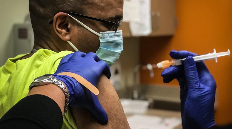 Amari Walls, 33 from Dayton gets his COVID-19 shot Monday at Five River Health Centers on Salem.