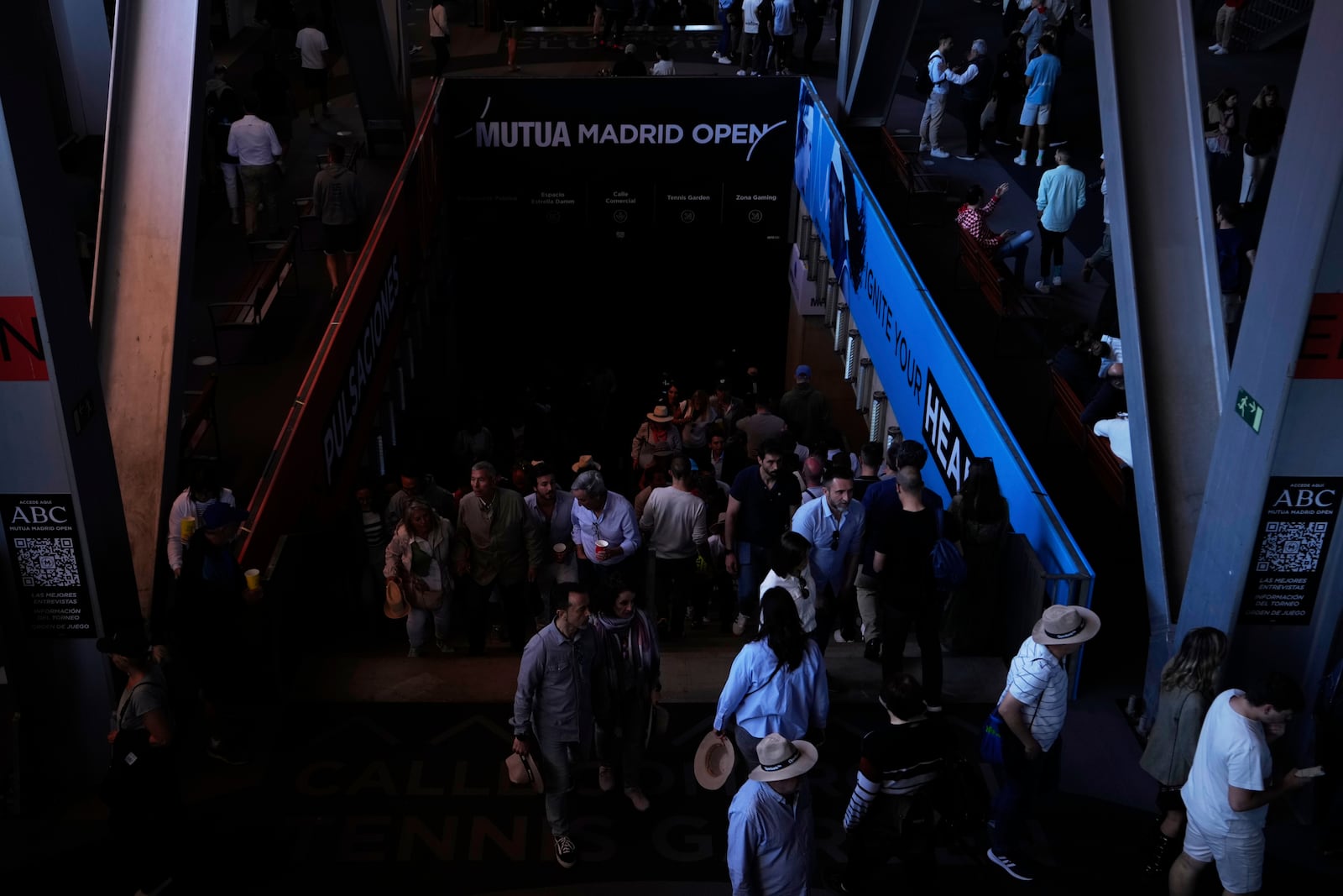Spectators roam inside the Madrid Open tennis tournament venue during a general blackout in Madrid, Monday, April 28, 2025. (AP Photo/Manu Fernandez)
