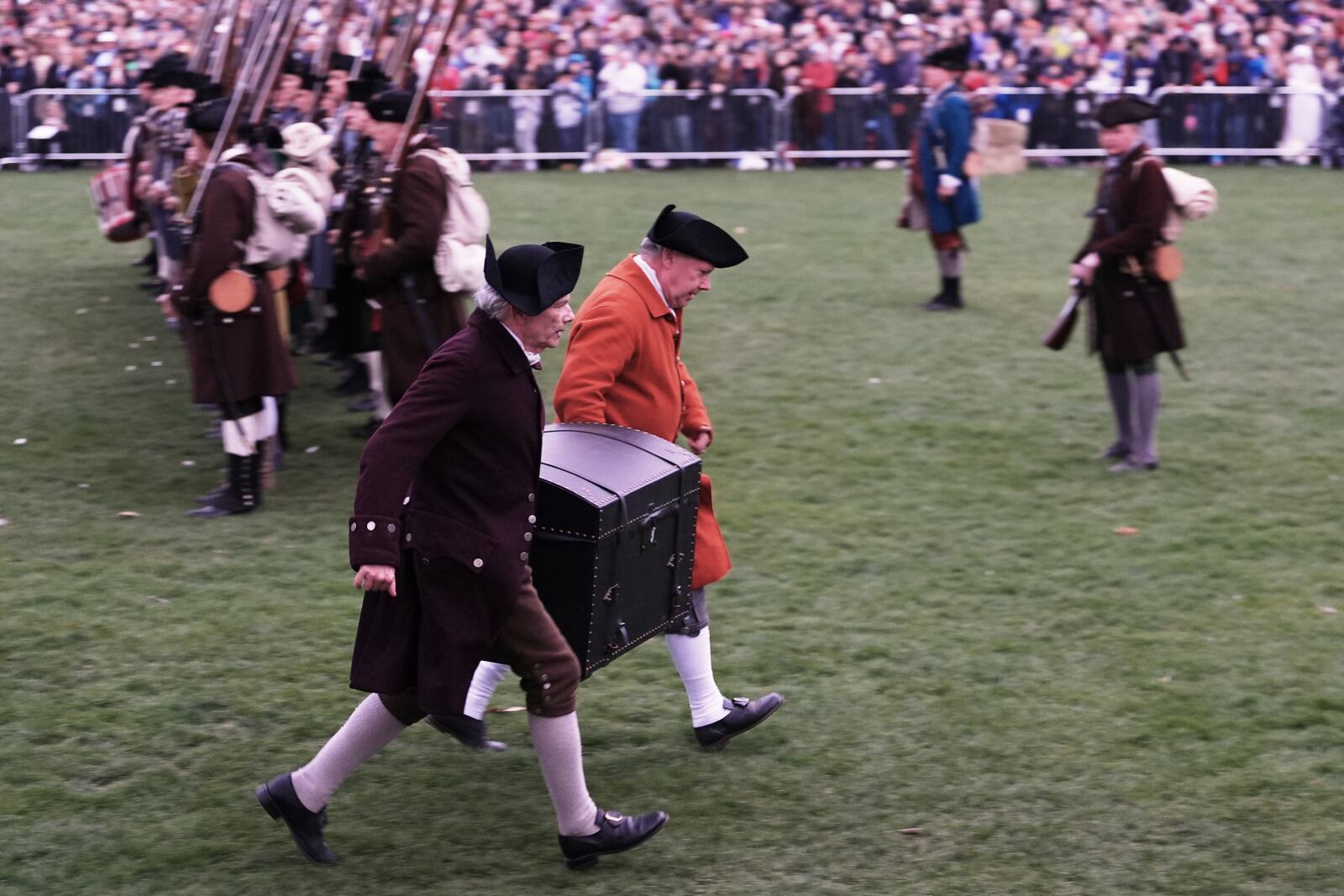 Colonial men carry the papers of John Hancock away from the advancing British Regulars during a reenactment celebration of the 250th anniversary of the Battle of Lexington and start of the American Revolution, Saturday, April 19, 2025, in Lexington, Mass. (AP Photo/Charles Krupa)