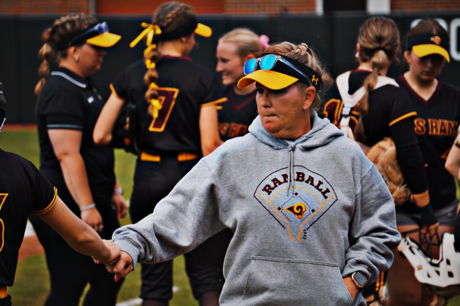 Ross coach Christi Luckett fist bumps a player in between innings during the Rams' Division III regional semifinal against Western Brown on Wednesday at Miami University. CHRIS VOGT / CONTRIBUTED