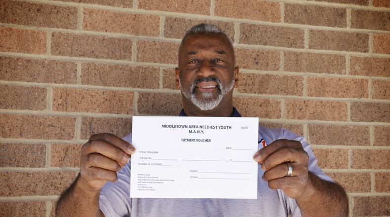 Chuck Hall, principal at Marshall High School in Middletown, shows one of the vouchers the school uses when students need to purchase clothes as part of the Middletown Area Neediest Youth (MANY) program. NICK GRAHAM/STAFF
