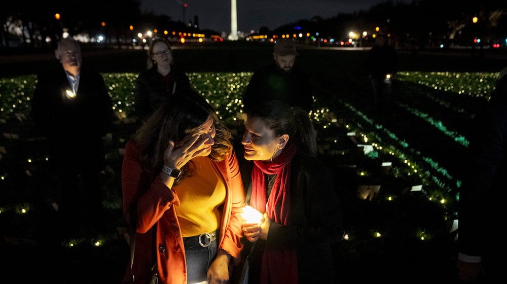 FILE - Madiha Maria, left, cries with Rana Abbas Taylor of Northville, Mich., who lost her only sister, brother-in-law and their three children to a drunk driver, during a candlelight vigil for people who had family members killed by drunk drivers, Tuesday, Nov. 19, 2024, on the National Mall, in Washington. (AP Photo/Jacquelyn Martin, File)