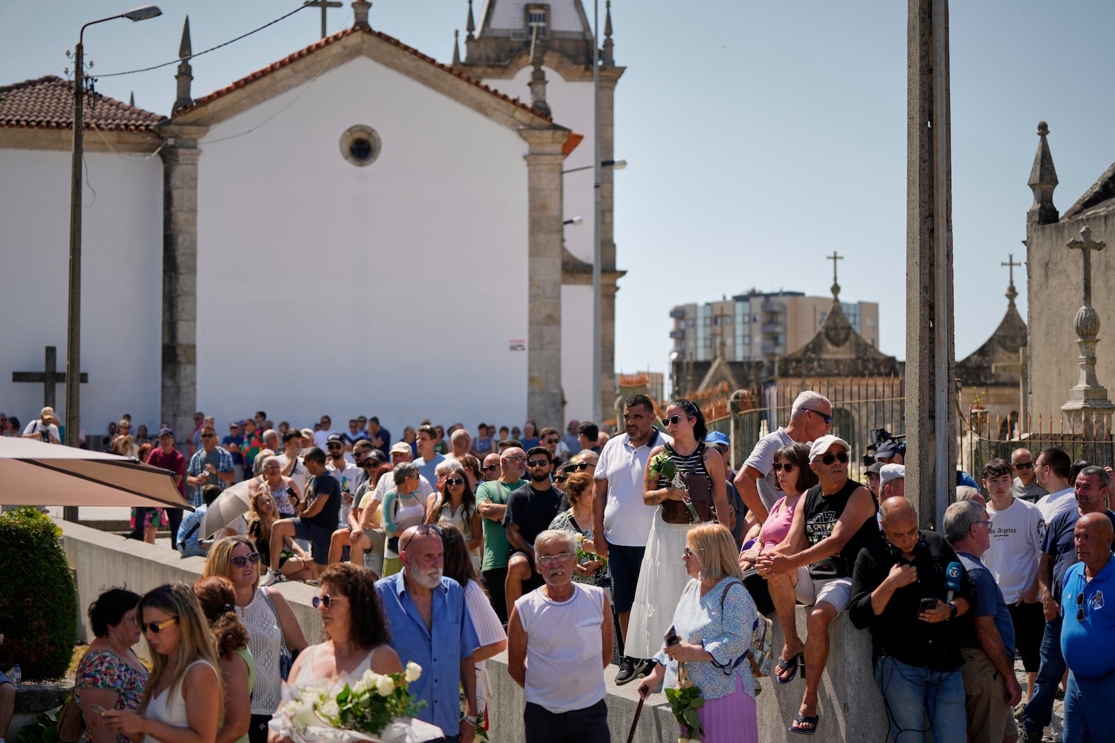 People gather at the church where the bodies of Liverpool forward Diogo Jota and André Silva have been brought for a wake and funeral in Gondomar, near Porto, Portugal, on Friday, July 4, 2025. (AP Photo/Manu Fernandez)