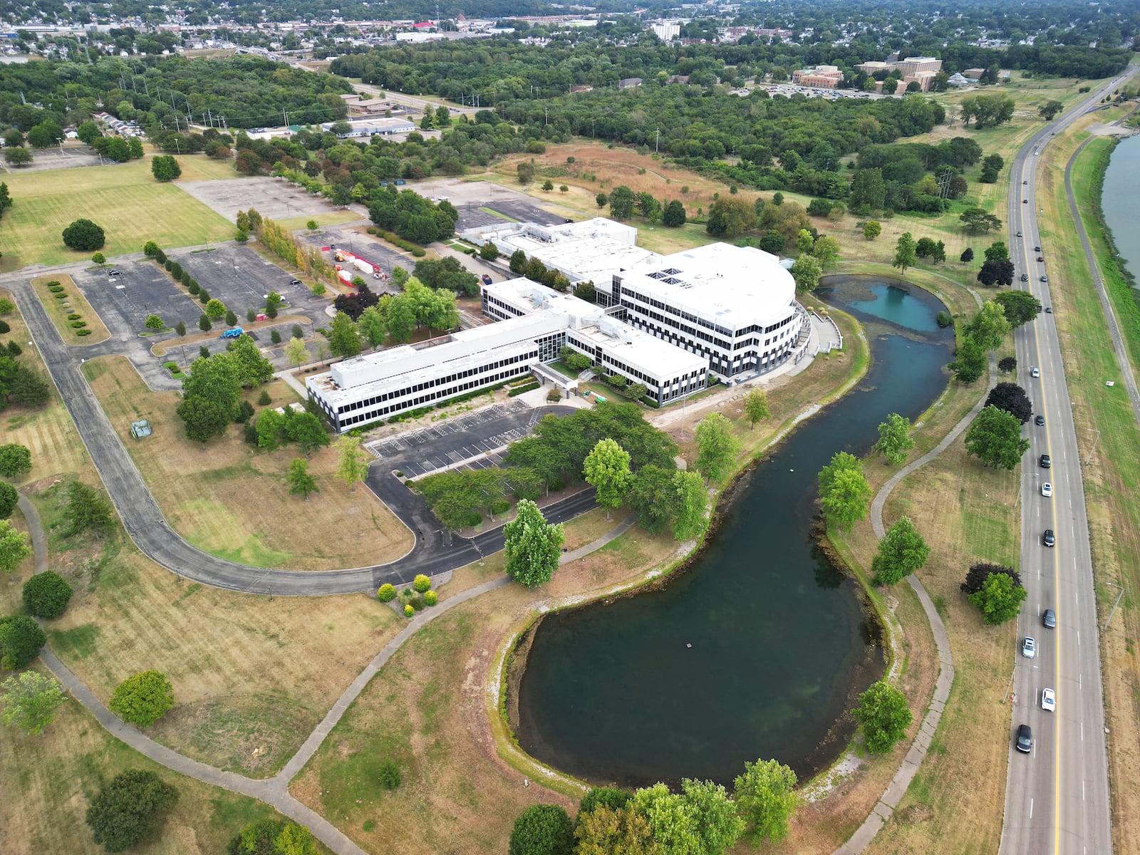 As part of Miami University's polytechnic initiative, the school is planning to develop a master plan for its Hamilton regional campus after it acquired nearly 55 acres. Pictured is the former Vora Tech building on Knightsbridge Drive that will house the new Advanced Manufacturing and Workforce Hub, a partnership with Butler Tech, the city of Hamilton, Hamilton City Schools and 30 businesses, among others. Miami University's southern campus is in the top right corner of this photo taken in August 2025. NICK GRAHAM / STAFF