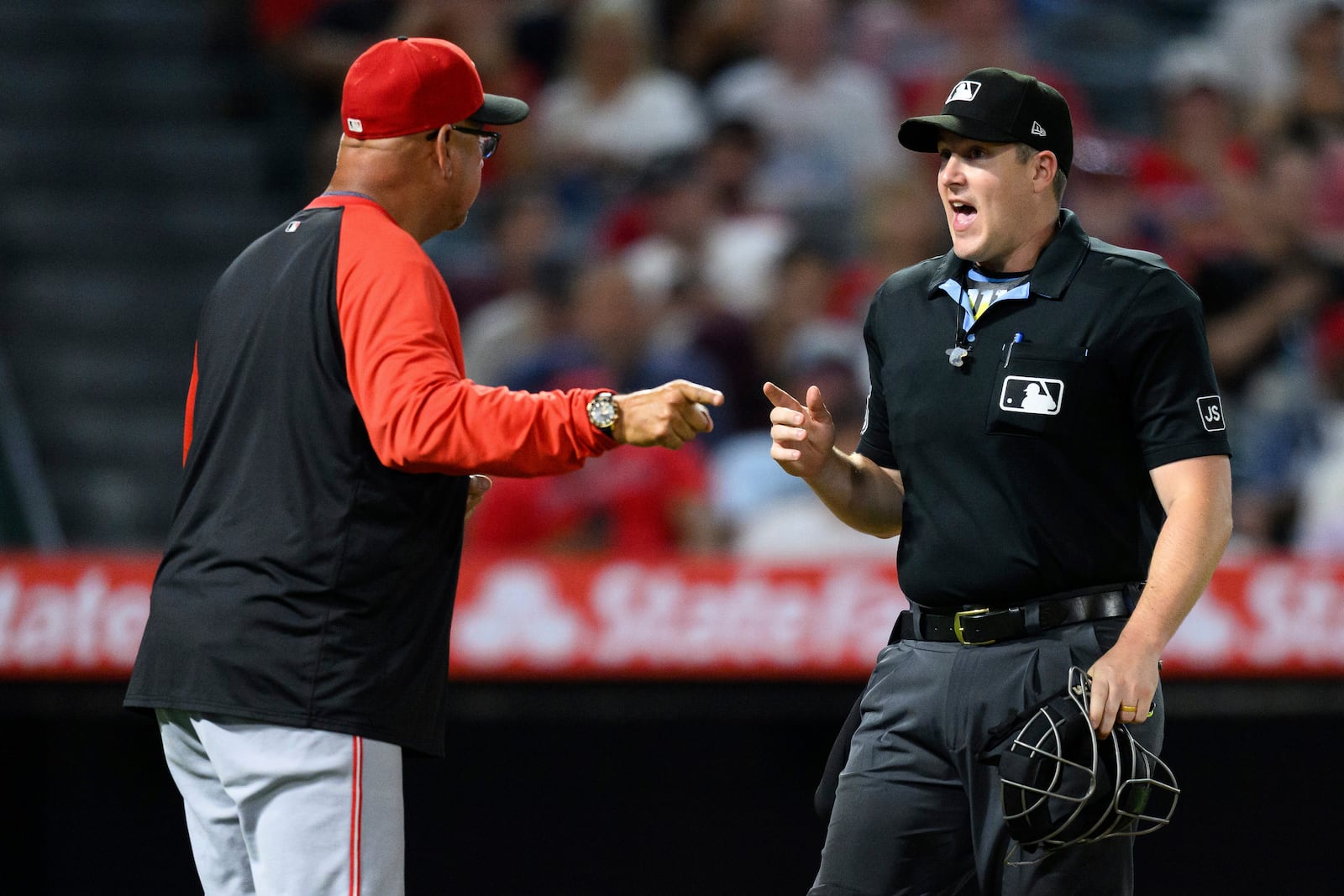 Umpire Brennan Miller, right, argues with Cincinnati Reds manager Terry Francona after calling a foul ball during the eighth inning of a baseball game against the Los Angeles Angels Wednesday, Aug. 20, 2025, in Anaheim, Calif. (AP Photo/William Liang)
