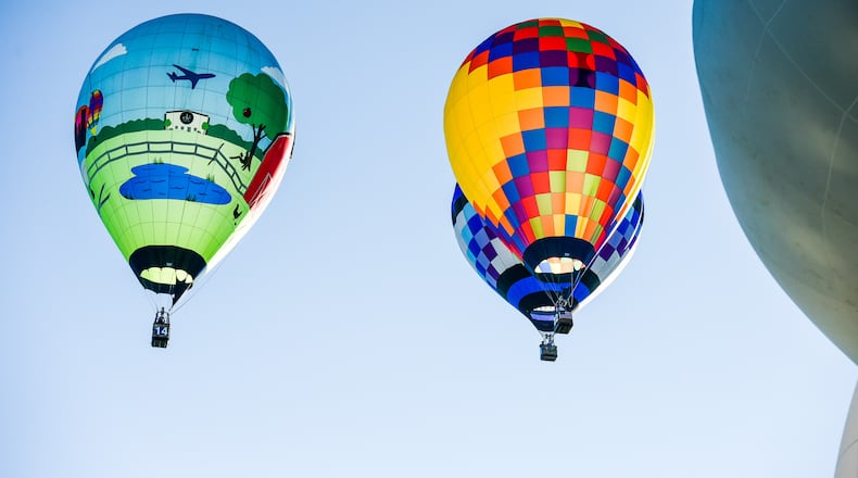 Competition balloons launched from off-site and flew over Hook Field to drop their markers as close to the target as possible Saturday morning during the Ohio Challenge Hot Air Balloon Festival at Smith Park in Middletown. Special shape balloons inflated on-site for attendees to get a closer look at them. NICK GRAHAM/STAFF