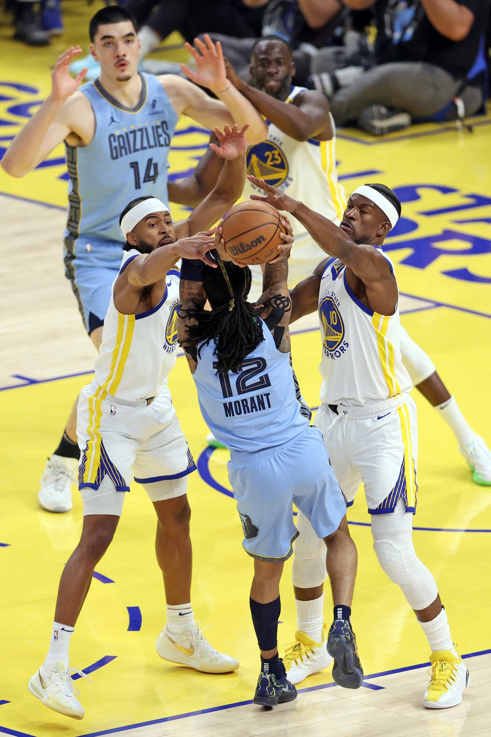 State Warriors' Moses Moody, left, and Jimmy Butler III (10) defend against Memphis Grizzlies' Ja Morant (12) during the first half of during an NBA play-in tournament basketball game in San Francisco, Tuesday, April 15, 2025. (Scott Strazzante/San Francisco Chronicle via AP)