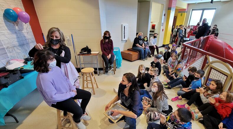 Jody Cole, from American Hair Company, cuts the hair of fourth-grader Sophia Muniz. Several Madison Elementary School students and teachers donated their hair Monday, March 1, 2021 to help others who made need it. NICK GRAHAM / STAFF