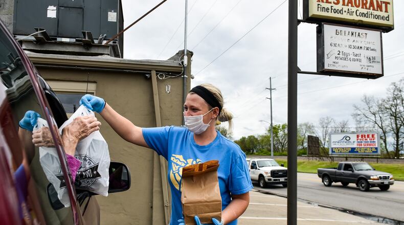Alli Rohan brings a curbside order out to a customer at Hyde’s Restaurant in Hamilton. Hyde’s opened back up for curbside orders and are taking orders 24-hours in advance with a limited menu. NICK GRAHAM / STAFF