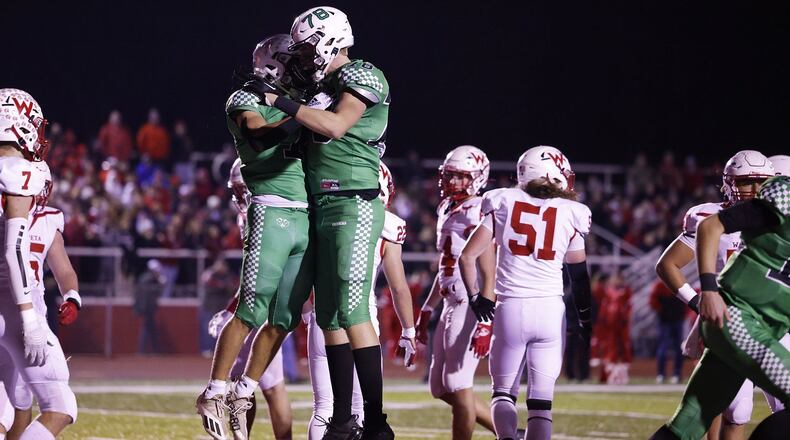 Badin's Zach Yordy, left, jumps to celebrate his touchdown with teammate Patrick Ray in their Division III Regional Semifinal football game against Wapakoneta Friday, Nov. 11, 2022 at Trotwood-Madison High School. Badin won 16-9. NICK GRAHAM/STAFF