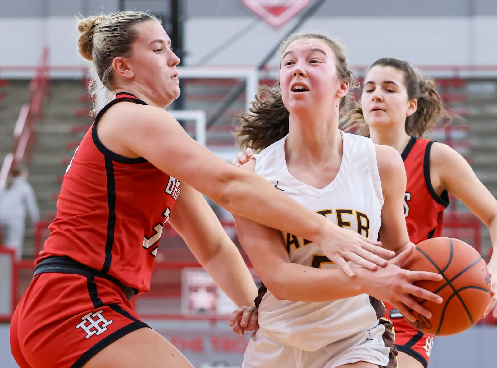 Alter senior guard Alina Overman drives with pressure from Cincinnati Indian Hill's Mia Sulfsted during a Division IV district final on Saturday, Feb. 28 at Troy High School's Trojan Activities Center. Overman led the Knights with 11 points. BRYANT BILLING / STAFF