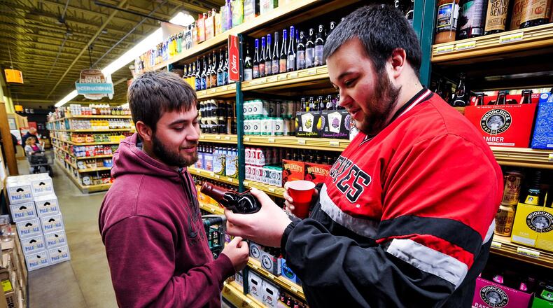 Brett Menser, left, and Alex Reindel drove from Tipp City to shop the large beer selection at Jungle Jim’s International Market in Fairfield for New Year’s Eve supplies. NICK GRAHAM/STAFF