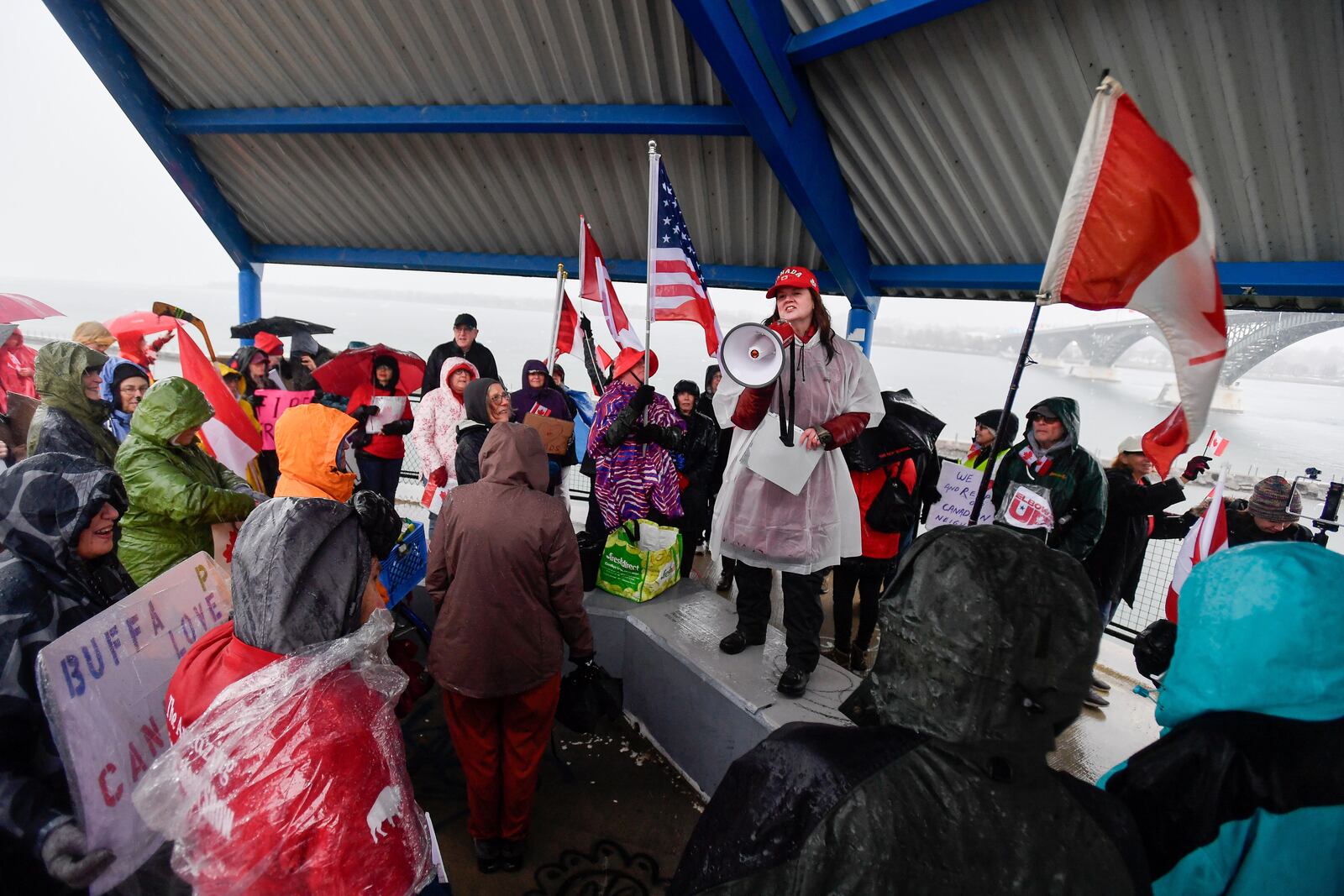 Kate Powers, center, addresses protesters gathered near The Peace Bridge border crossing in Buffalo, N.Y., Wednesday, April 2, 2025. (AP Photo/Adrian Kraus)