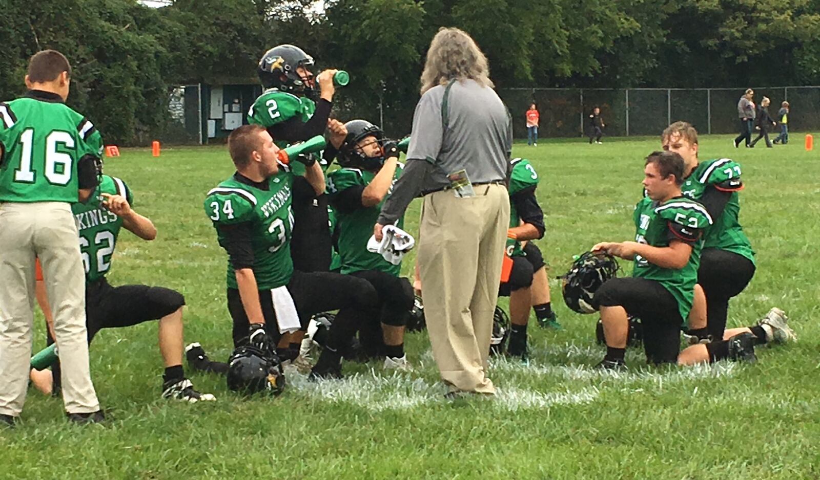 New Miami players take a water break during a timeout in Saturday night’s game against Marion Elgin at Mara Field in New Miami. RICK CASSANO/STAFF