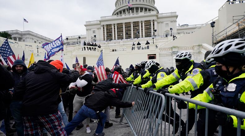FILE - Rioters supporting President Donald Trump try to break through a police barrier at the Capitol in Washington, on Jan. 6, 2021.(AP Photo/Julio Cortez, File)