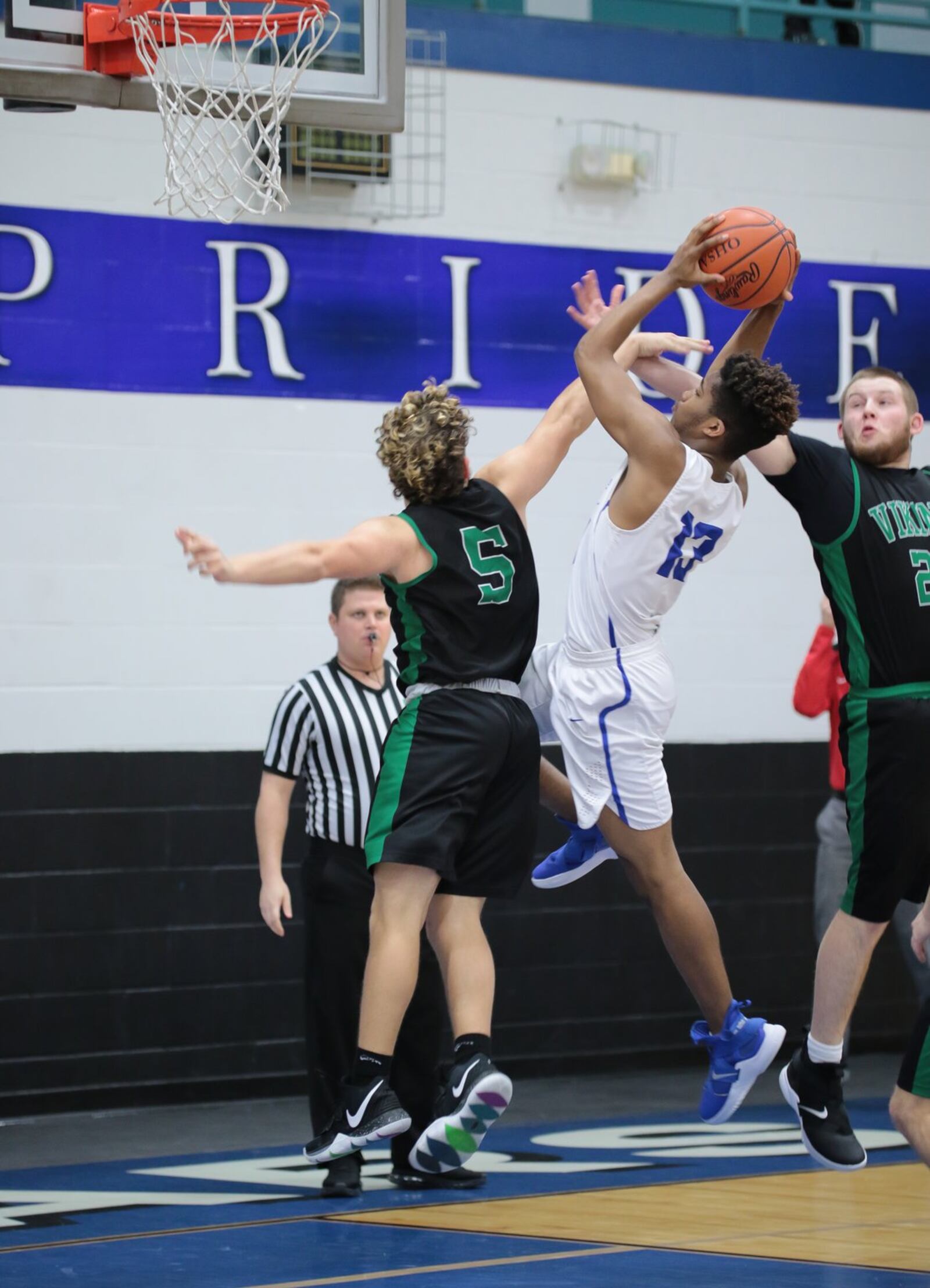 Cincinnati Christian’s Devin McKinnon shoots between New Miami’s Trey Robinette (5) and Ronnie Bowman during Tuesday night’s game in Fairfield Township. Host CCS won 54-37. PHOTO BY KRAE/WWW.KRAEPHOTOGRAPHY.COM