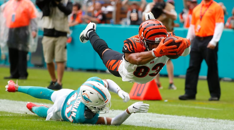 Cincinnati Bengals wide receiver Tyler Boyd (83) stretched for a touchdown as Miami Dolphins defensive back Nik Needham (40) is unable to defend, during the second half at an NFL football game, Sunday, Dec. 22, 2019, in Miami Gardens, Fla. (AP Photo/Wilfredo Lee)