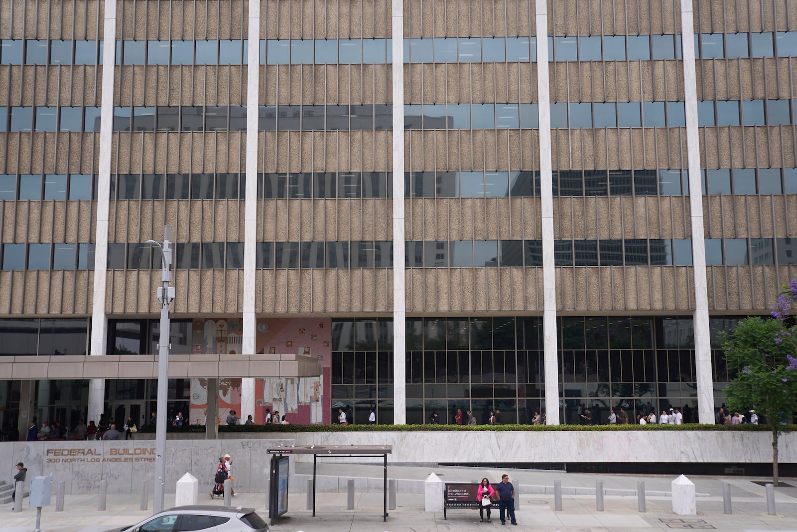 People line up outside the Los Angeles Federal Building in Los Angeles, housing the U.S. Immigration and Customs Enforcement (ICE) and U.S. Citizenship and Immigration Services (USCIS) on Wednesday, June 25, 2025. (AP Photo/Damian Dovarganes)