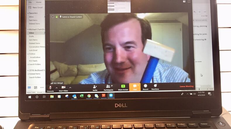 Hamilton Board of Education President Rob Weigel jokingly starts the district’s first tele-conferencing board meeting by using his child’s toy hammer in place of his regular president’s gavel. The governing boards of area school systems are forced to hold their meetings remotely via online conferencing platforms as they wait out the end of the state-ordered coronavirus shut down of all schools and school events. (Photo By Michael D. Clark/Journal-News)