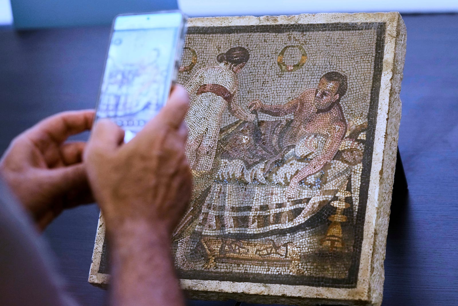 A Roman mosaic depicting a pair of lovers, which was repatriated from Germany, is displayed to journalists in the auditorium of Pompeii archaeological park, Tuesday, July 15, 2025. (AP Photo/Gregorio Borgia)