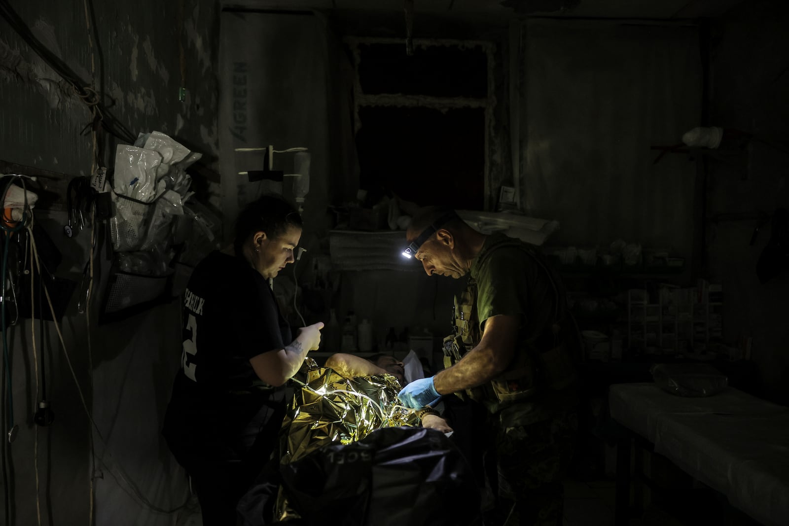 In this photo provided by Ukraine's 24th Mechanized Brigade press service, military medics give first aid to a wounded Ukrainian soldier at a medical stabilisation point in Donetsk region, Ukraine, Friday, July 25, 2025, (Oleg Petrasiuk/Ukraine's 24th Mechanized Brigade via AP)