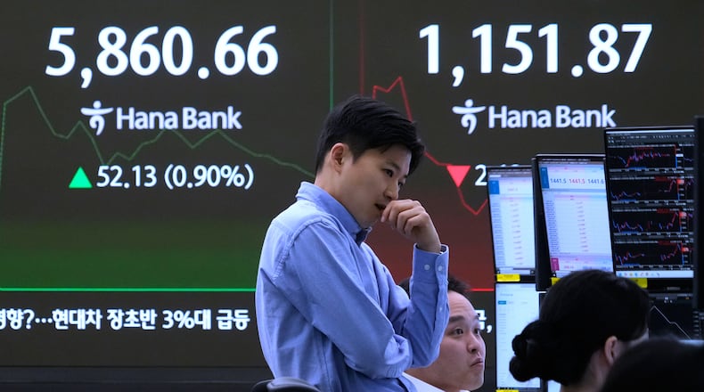 A currency traders reacts near a screen showing the Korea Composite Stock Price Index (KOSPI), left, and the foreign exchange rate between U.S. dollar and South Korean won at the foreign exchange dealing room of the Hana Bank headquarters in Seoul, South Korea, Monday, Feb. 23, 2026. (AP Photo/Ahn Young-joon)