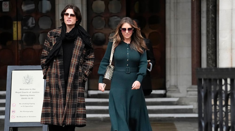 Elizabeth Hurley, right, leaves the Royal Courts of Justice on day four of the trial over allegations of unlawful information gathering brought against Associated Newspapers Limited, Thursday, Jan. 22, 2026, in London. (Jordan Pettitt/PA via AP)