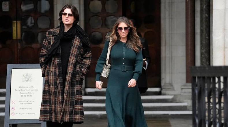 Elizabeth Hurley, right, leaves the Royal Courts of Justice on day four of the trial over allegations of unlawful information gathering brought against Associated Newspapers Limited, Thursday, Jan. 22, 2026, in London. (Jordan Pettitt/PA via AP)