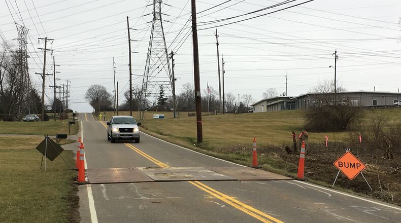 A vehicle slows going over road plates that have been placed in the 600 block of Todhunter Road after a sanitary sewer line break caused a sinkhole. Monroe officials said the road sank about three inches. ED RICHTER/STAFF