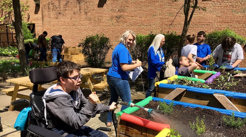 Hamilton High School special needs student Jacob Strong waters an in-school garden where he and his classmates grow vegetables and learn science and nature lessons. The court-yard garden is enclosed by the Butler County high school and allows the students to grow and harvest vegetables to take home in early fall.