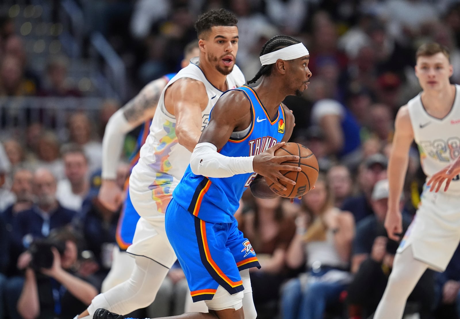 Oklahoma City Thunder guard Shai Gilgeous-Alexander, front, drives the lane as Denver Nuggets forward Michael Porter Jr. defends in the first half of Game 6 in the Western Conference semifinals of the NBA basketball playoffs Thursday, May 15, 2025, in Denver. (AP Photo/David Zalubowski)