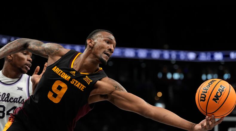 Arizona State's Shawn Phillips Jr. reaches for the ball as Kansas State's Ugonna Onyenso (34) watches during the first half of an NCAA college basketball game in the first round of the Big 12 Conference tournament, Tuesday, March 11, 2025, in Kansas City, Mo. (AP Photo/Charlie Riedel)