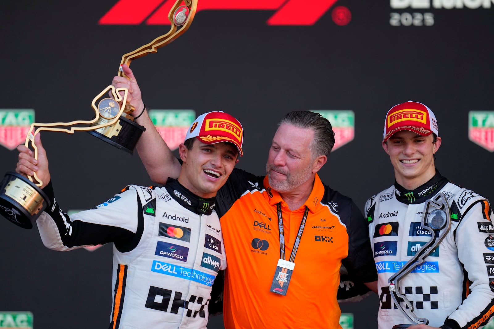 McLaren driver Lando Norris of Britain, left, celebrates on the podium with Zak Brown, McLaren chief, center, and McLaren driver Oscar Piastri of Australia after winning the Formula One Monaco Grand Prix race at the Monaco racetrack in Monaco, Sunday, May 25, 2025. (AP Photo/Manu Fernandez)