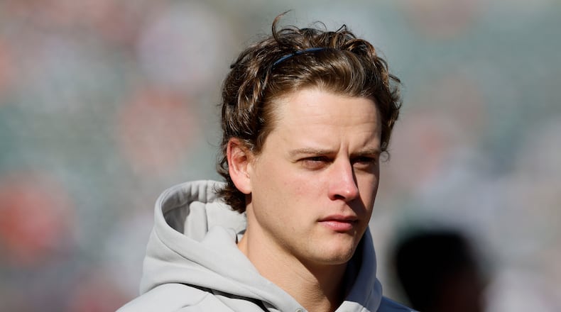 Injured Cincinnati Bengals quarterback Joe Burrow walks on the field before an NFL football game against the New England Patriots, Sunday, Nov. 23, 2025, in Cincinnati. (AP Photo/Jay LaPrete)