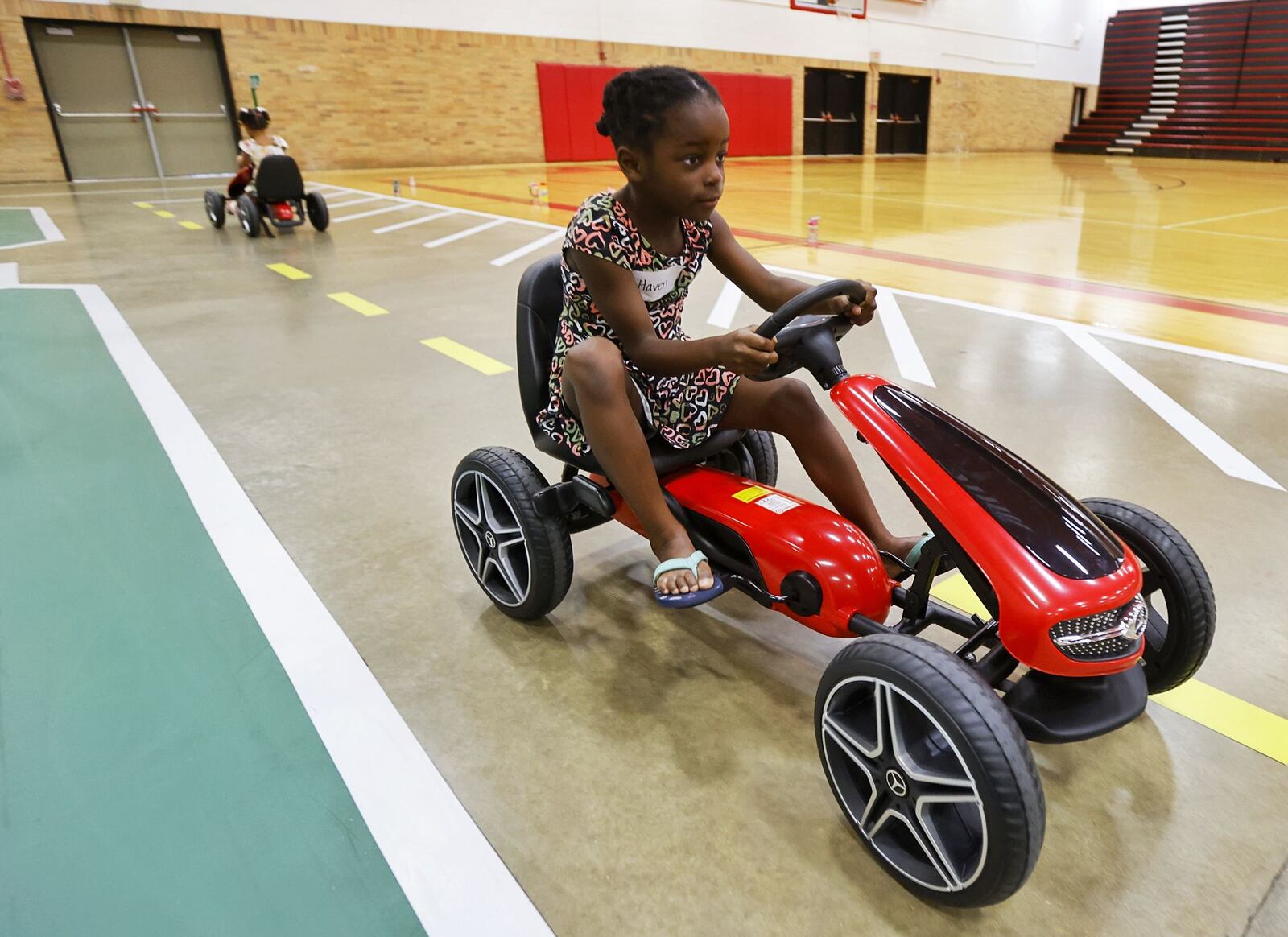 Haven Sweemer, 5, drives a pedal car during Lakota Safety Village.  Lakota schools, West Chester Police Department, Butler County Sheriff's Office and other have partnered for Lakota Safety Village to teach young children going into kindergarten school etiquette, bus and car safety, fire safety and more at Lakota Freshman School in West Chester Township. NICK GRAHAM/STAFF