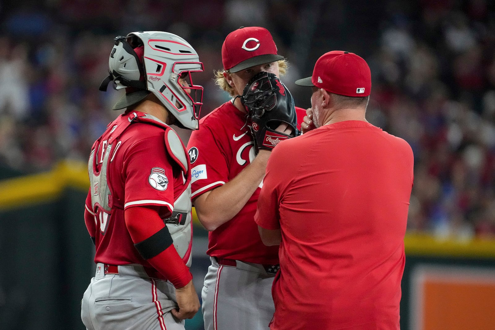 Cincinnati Reds pitcher Andrew Abbott, center, talks with catcher Jose Trevino, left, and pitching Derek Johnson, right, after giving up three runs to the the Arizona Diamondbacks during the first inning of a baseball game Saturday, Aug. 23, 2025, in Phoenix. (AP Photo/Darryl Webb)