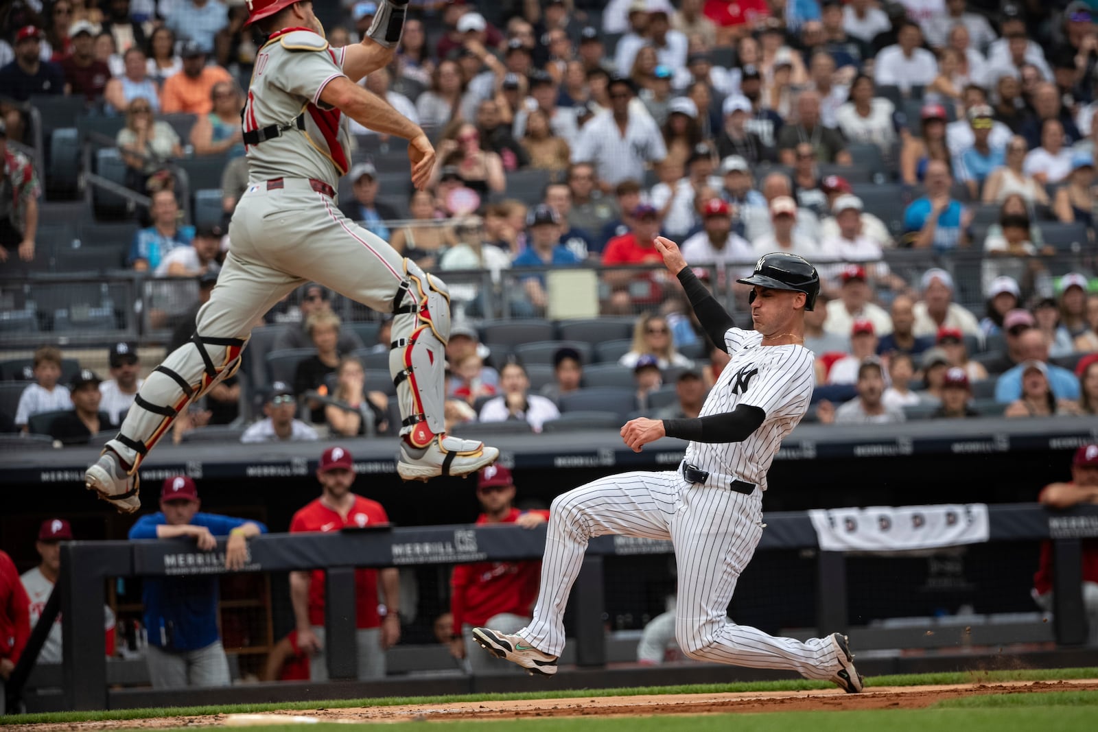 New York Yankees' Cody Bellinger, right, is about to be out at home plate against Philadelphia Phillies catcher J.T. Realmuto, left, during the third inning of a baseball game, Sunday, July 27, 2025, in New York. (AP Photo/Angelina Katsanis)