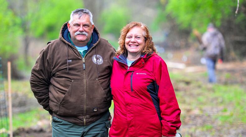 Troy and Kathy Schwable stand in a clearing where they and others in 2018 planted 100 trees, along with other members of Hamilton Conservation Corps and Hamilton city employees at Riverside Natural Area. NICK GRAHAM/STAFF