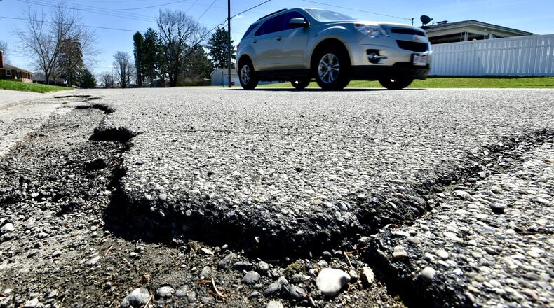 A vehicle travels by a rough patch of W. Roger Drive Wednesday, April 3, 2019 in Trenton. The new 10.5-cent-per-gallon gas tax increase has allowed Trenton to reduce a road levy request from up to 6 mills to 3.9 mills. NICK GRAHAM/STAFF