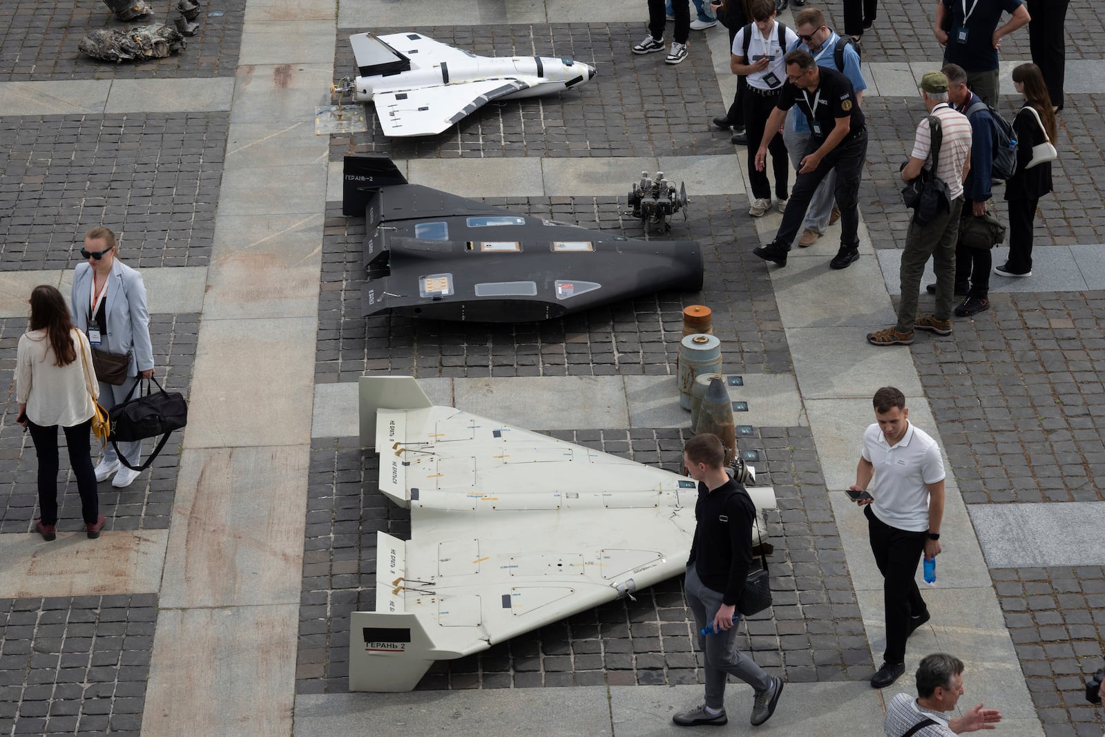 Visitors watch damaged Russian drones during the International Conference on Expanding Sanctions Against Russia in Kyiv, Ukraine, Friday, June 27, 2025. (AP Photo/Efrem Lukatsky)