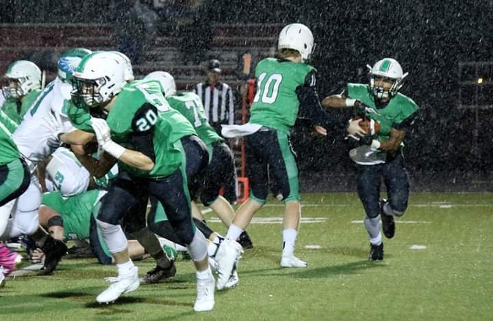 Badin’s Davon Starks (1) takes a handoff from Zach Switzer and gets some lead blocking from Alex DeLong (20) during Friday night’s 38-21 win over Chaminade Julienne at Fairfield Stadium in Fairfield. CONTRIBUTED PHOTO BY TERRI ADAMS