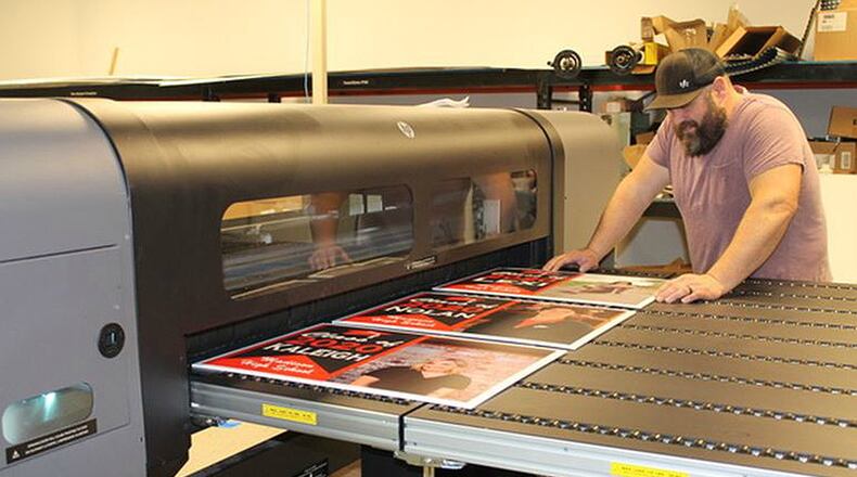 Andy Short from Digital Visuals Inc. in Middletown works on senior signs that were purchased for area high school seniors. PROVIDED