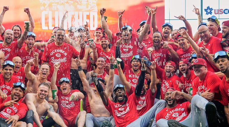 The Cincinnati Reds celebrate as they take a team photo after making it into the playoffs after a baseball game against the Milwaukee Brewers Sunday, Sept. 28, 2025, in Milwaukee. (AP Photo/Morry Gash)